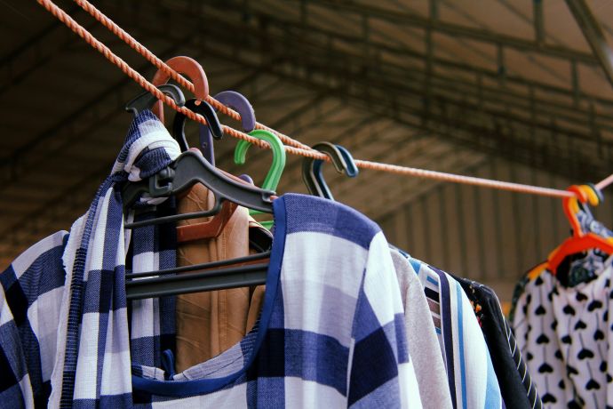 Close-up of vibrant clothes hanging on a line, showcasing various patterns and colors on hangers.